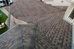 Overhead view of a multi-sloped brown architectural shingle roof installation with ridge capping and flashing by AKRoN Roofing.